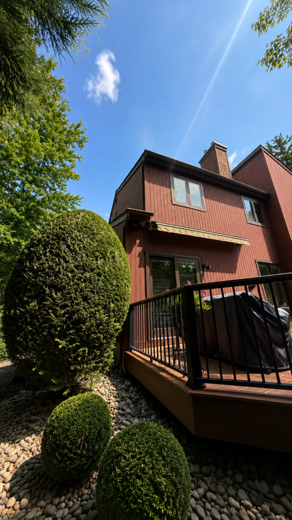 red trim painting On house with landscaped garden and deck